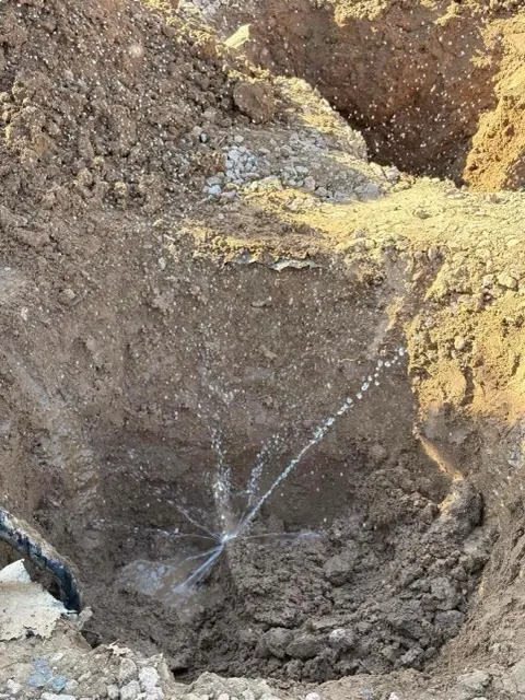 A broken main water line excavated by Trident Plumbing