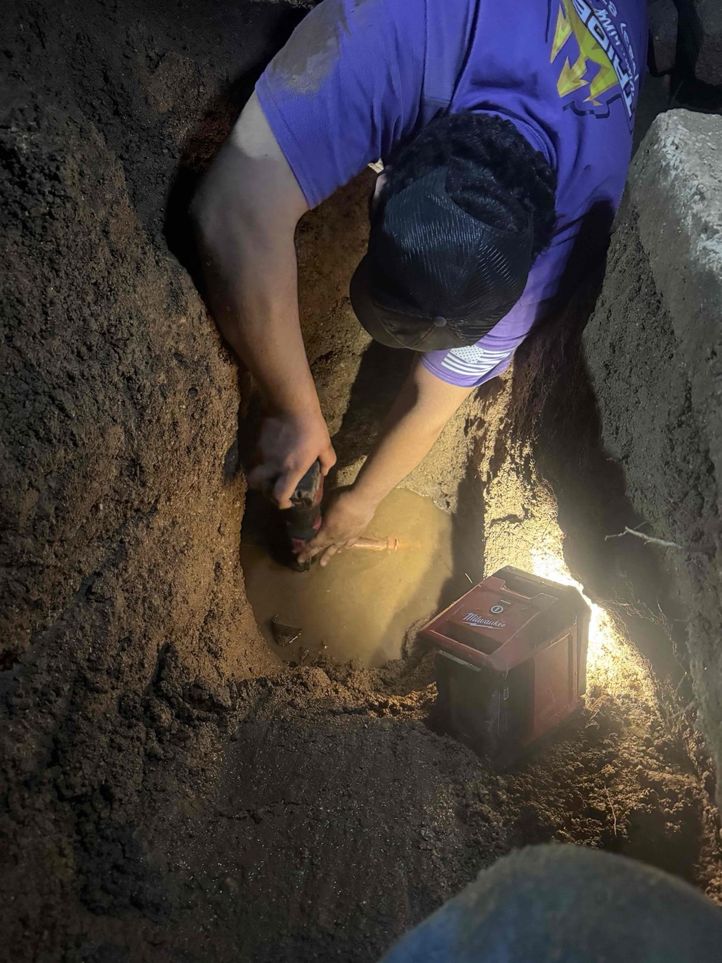 Trident plumber working in an open trench on a water line repair