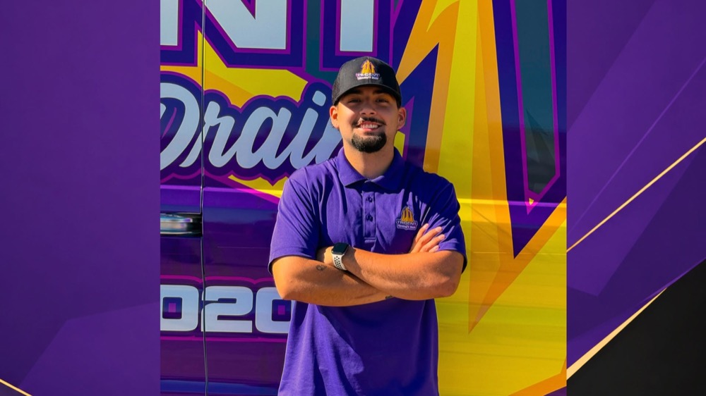 A Trident Plumbing & Drain team member in front of a branded company van