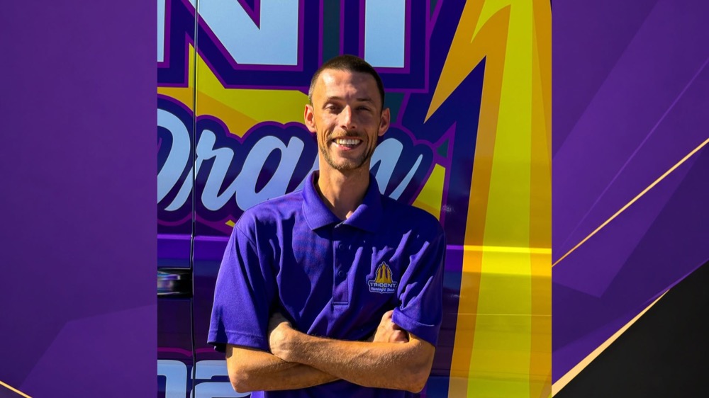 A Trident Plumbing & Drain team member in front of a branded company van