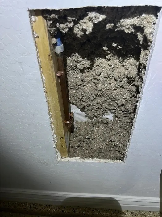 An opened ceiling with exposed copper pipe during a Trident repair, from Ben Tosuner's Google review
