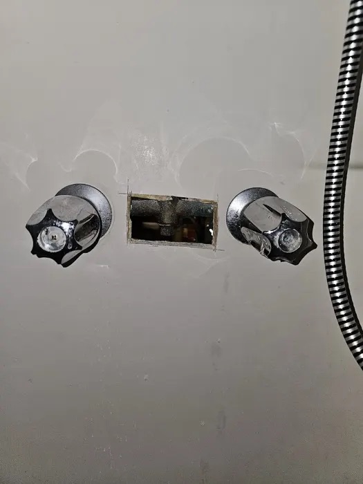 An opened wall exposing shower valves during a Trident repair, from Doris Bean's Google review