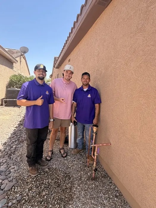 Two Trident plumbers with a customer beside fresh copper repair piping, from Huntington Coats' Google review