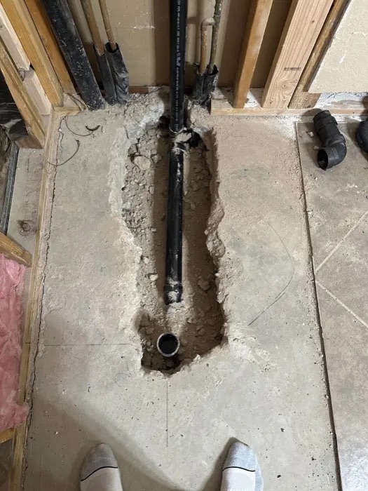 A relocated shower drain line set into a dug-out concrete slab, from Mike Anderson's Google review